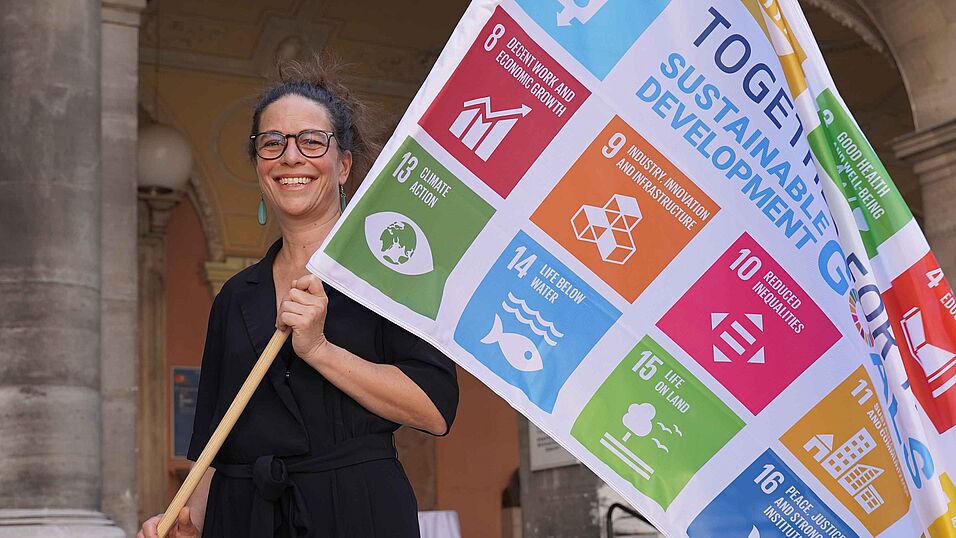 Kultur- und Sozialanthropologin Janina Meillan-Kehr mit der SDG Flagge