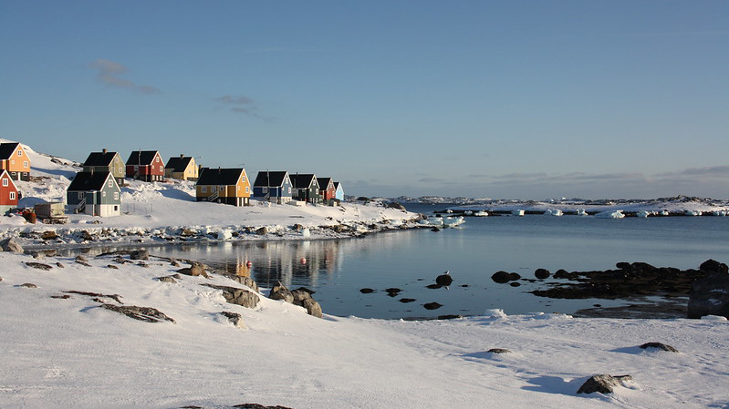 Besiedelte Küstenregion in Grönland, bunte Häuser in einer verschneiten Bucht © Nunataryuk